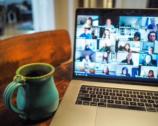 Hand coming out of laptop screen holding a heart