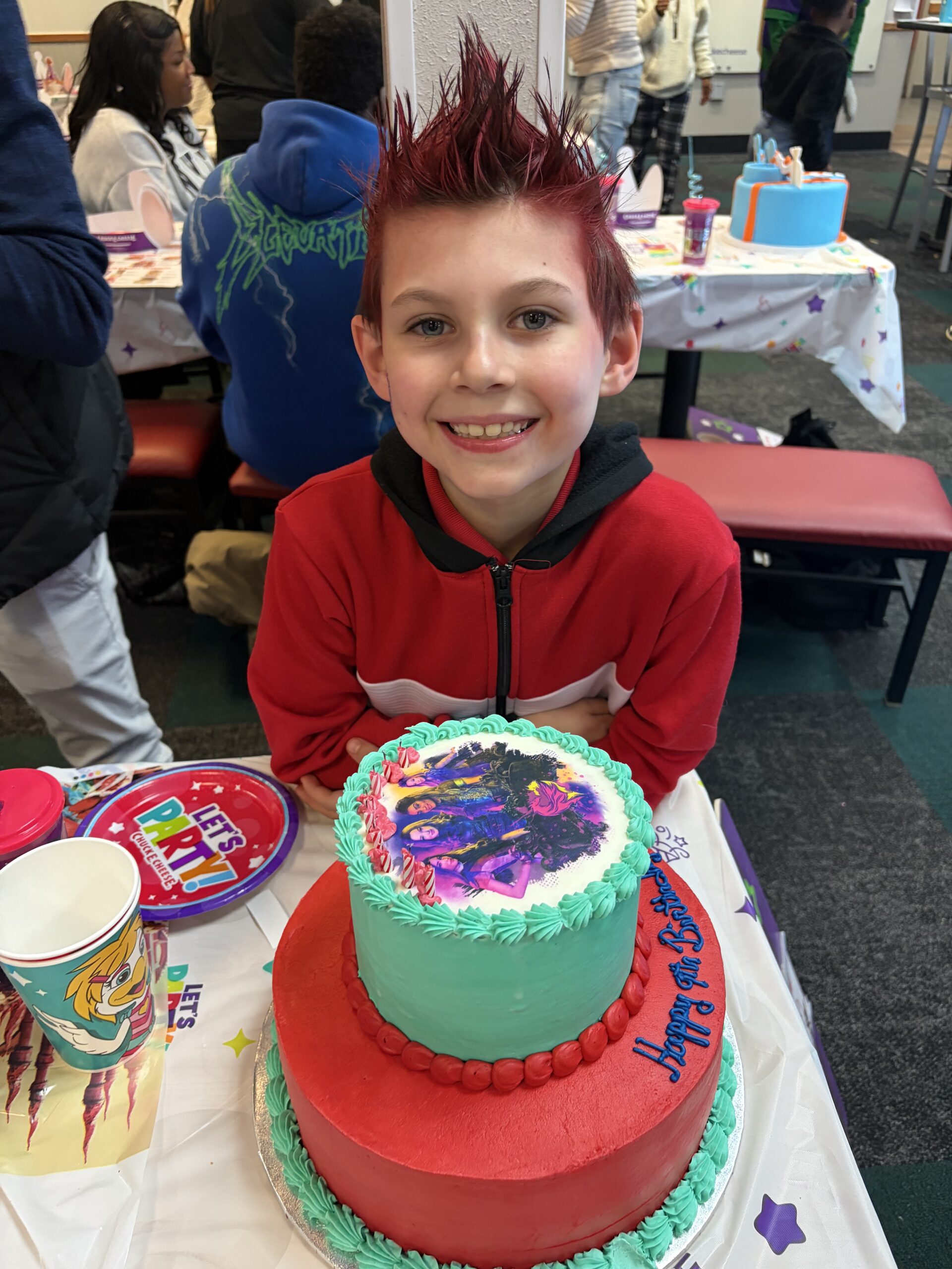 Smiling child forming heart shape with hands in front of his face